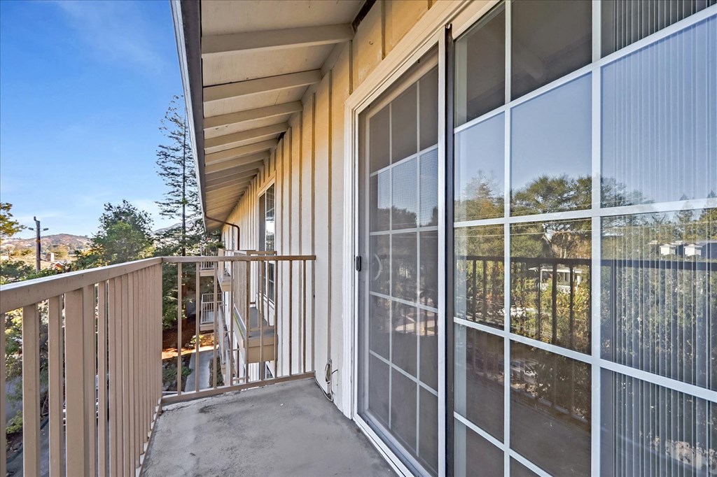 a balcony with a large glass door and a patio