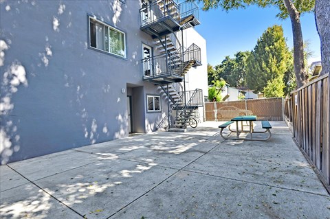 a patio with a fire escape on the side of a building