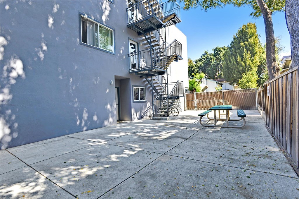 a patio with a fire escape on the side of a building