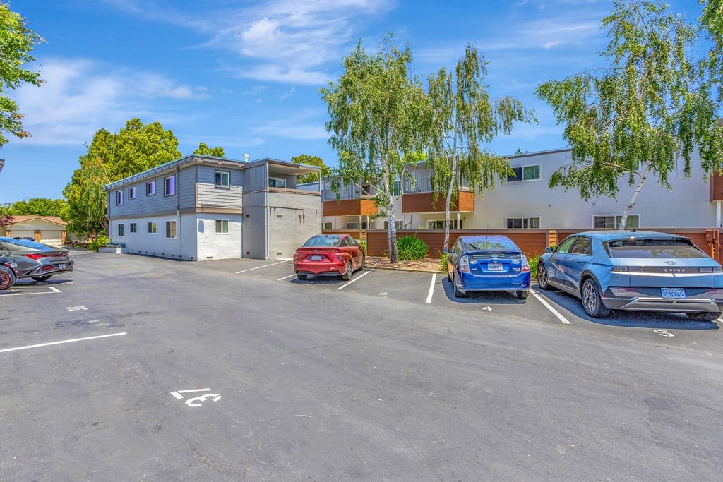 A parking lot with cars and a building in the background.
