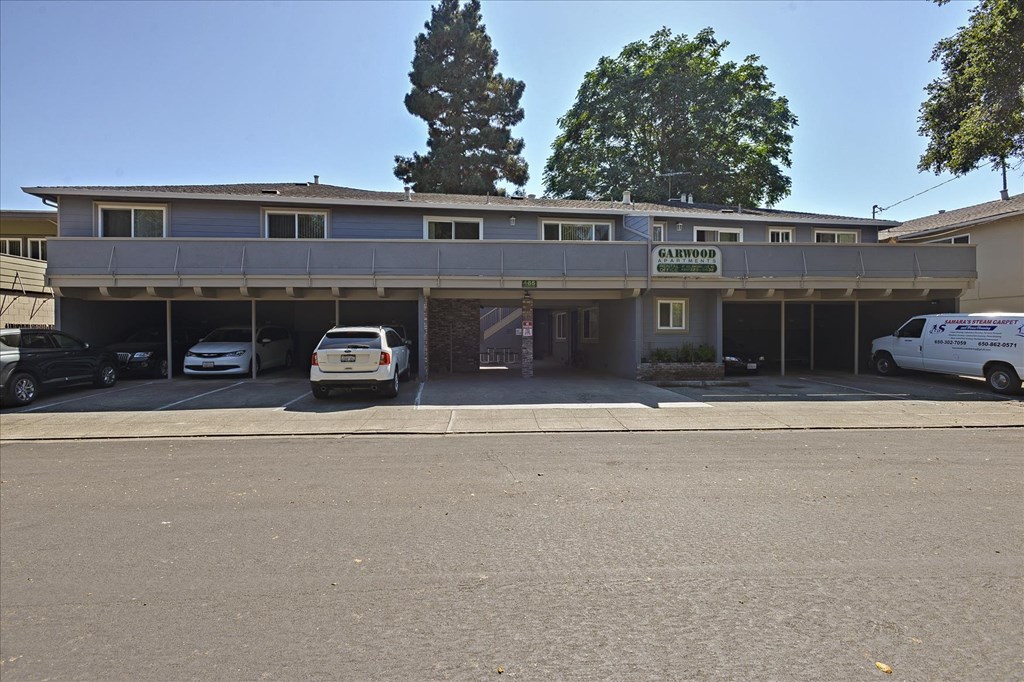 A parking lot in front of a building with a sign that says