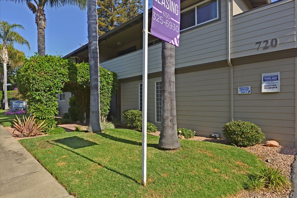 a purple sign in the front yard of a house