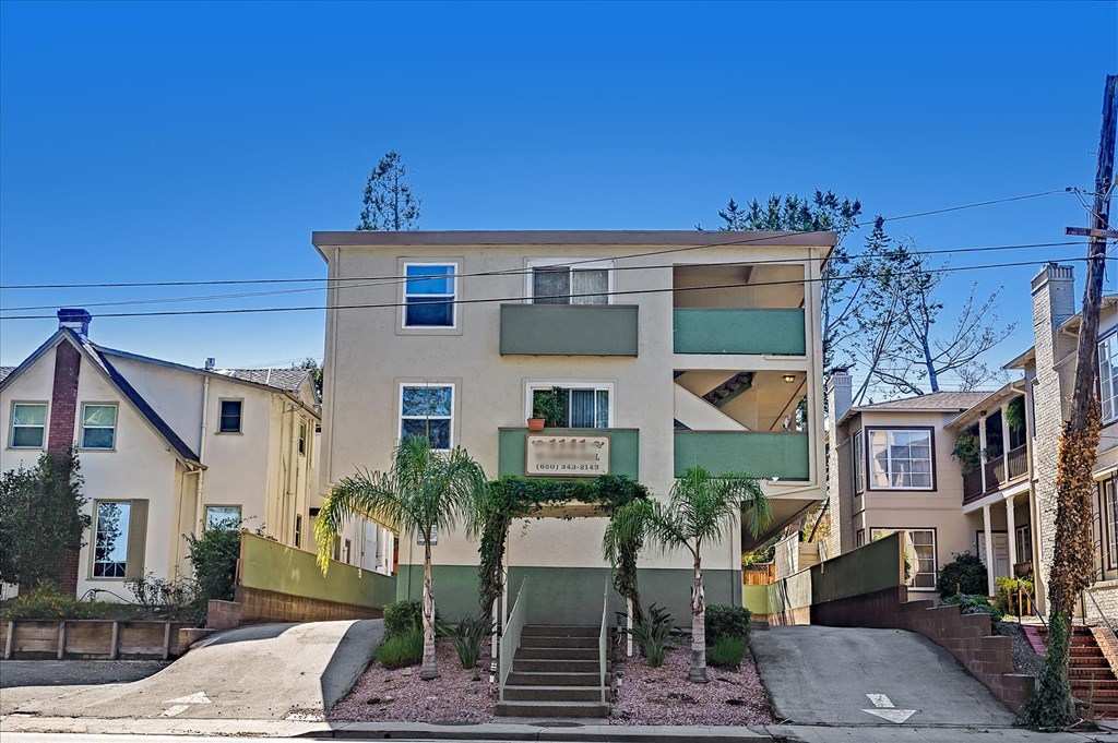 an apartment building with palm trees in front of it