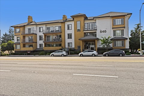 Apartment building number 540 with cars parked in front.