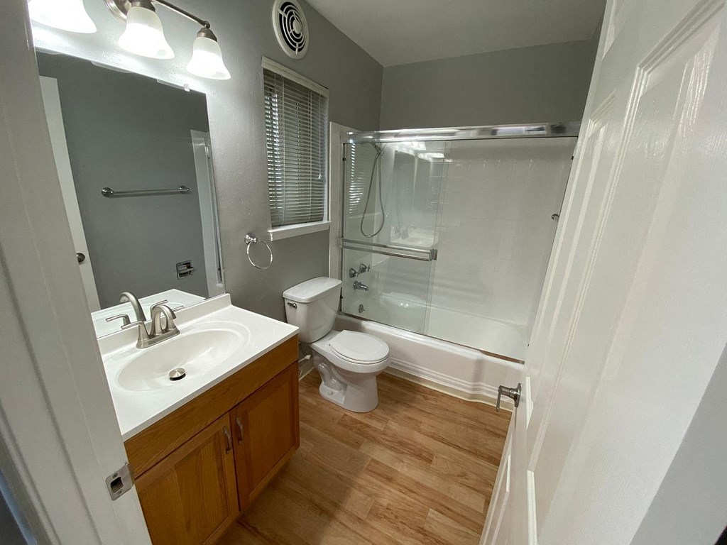 A bathroom with a toilet, sink, and shower.