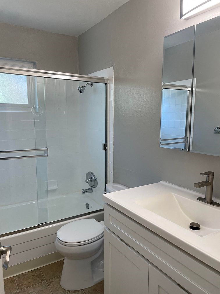 A white toilet sits next to a sink in a bathroom.