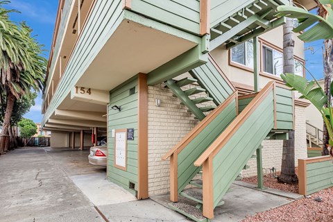 A green building with a staircase leading to the second floor.
