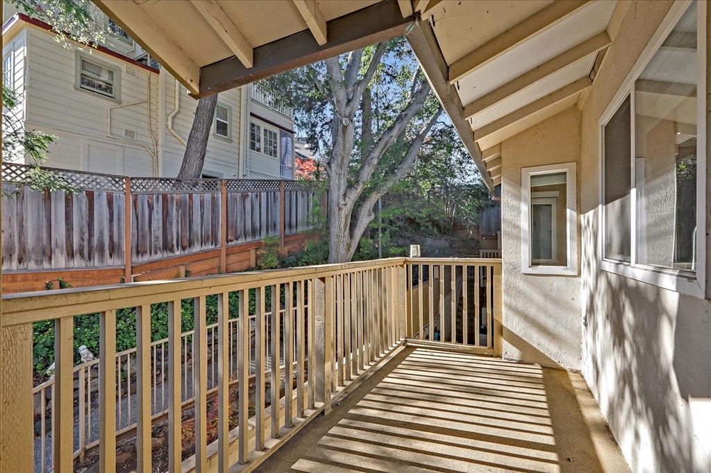 the balcony has a view of the yard and the house