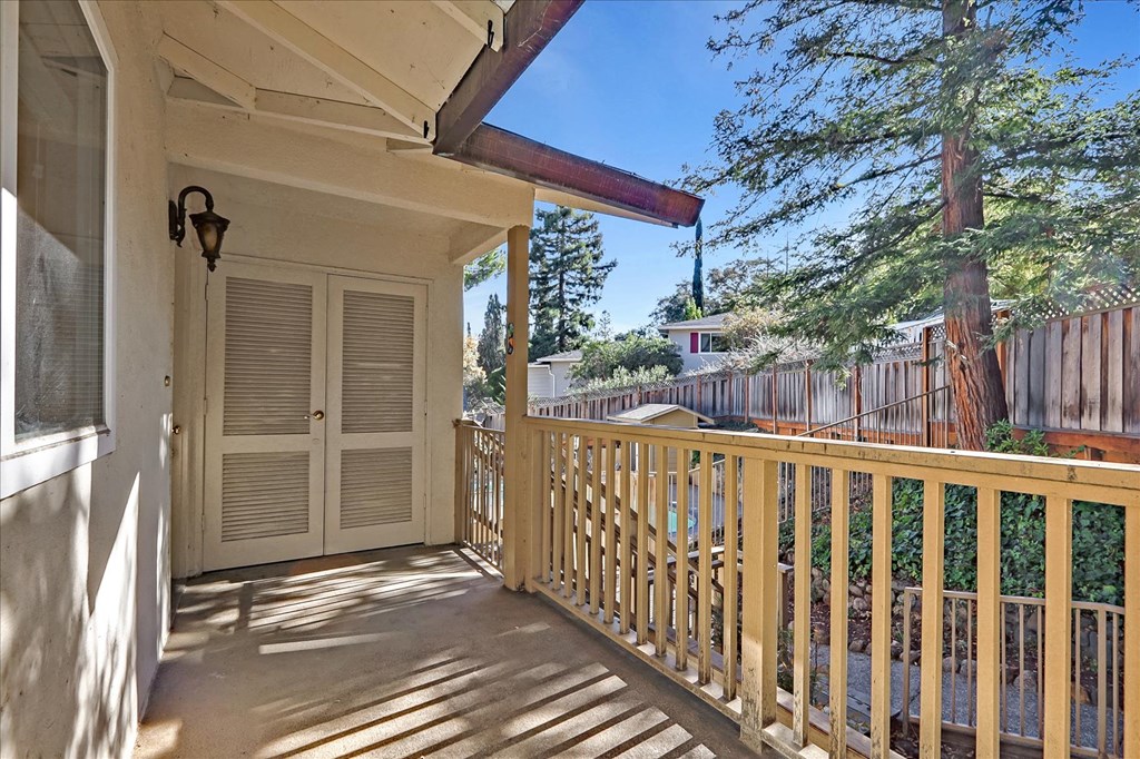 the balcony has a view of the yard and the trees