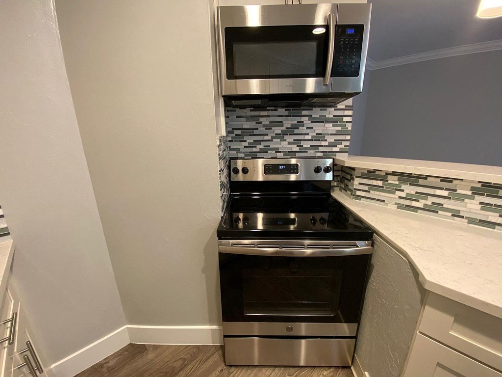 A modern kitchen with a stainless steel oven and microwave.