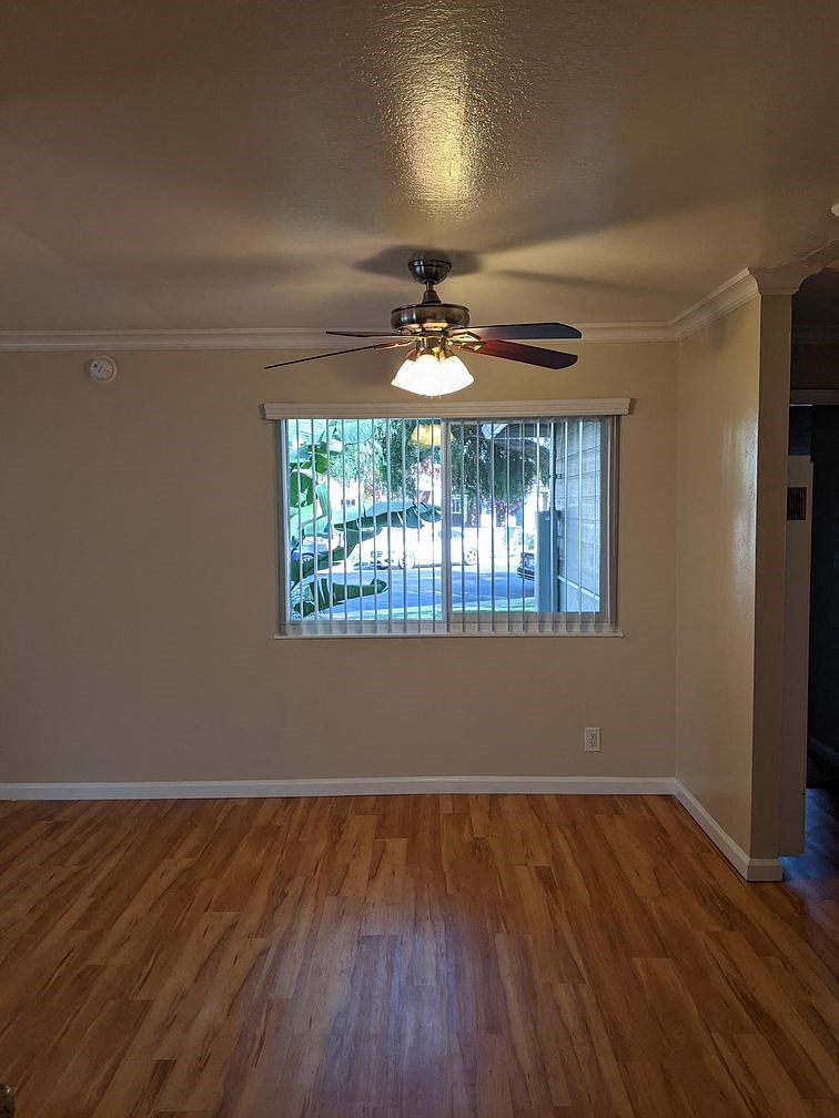A room with a ceiling fan and a window.