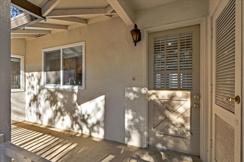 the front entrance of a house with a white door and a window