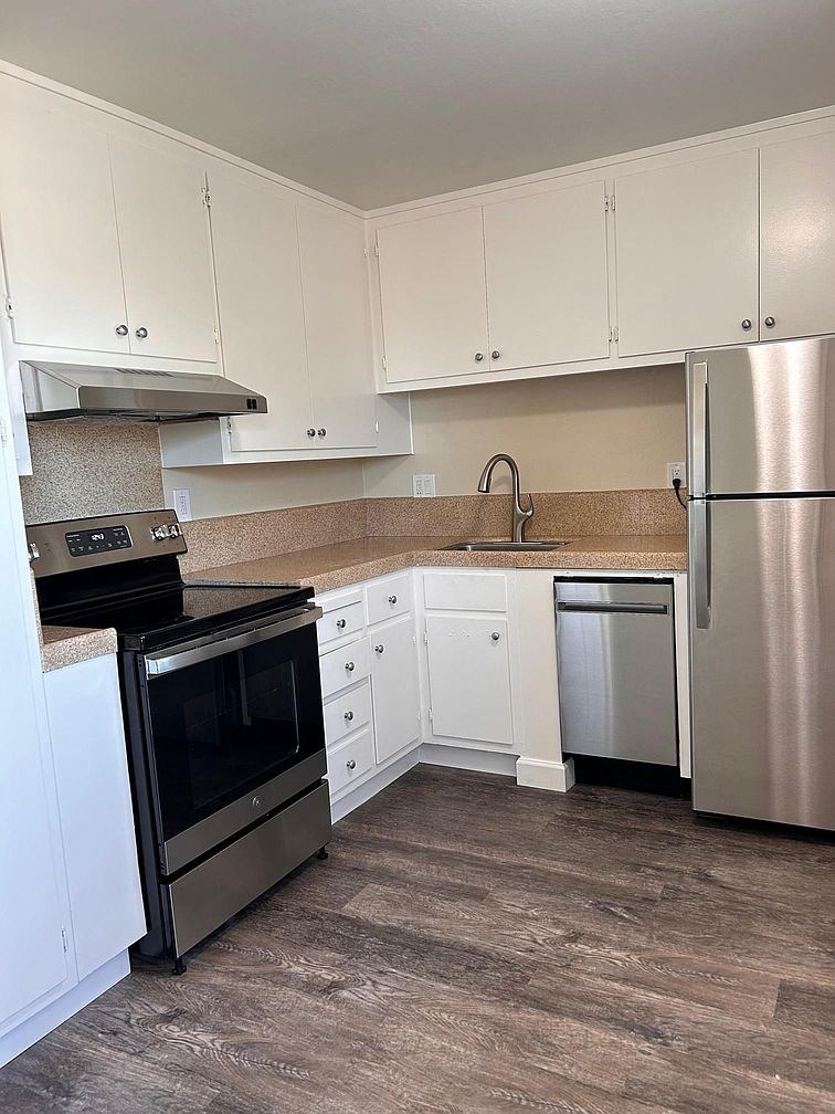 a kitchen with stainless steel appliances and white cabinets