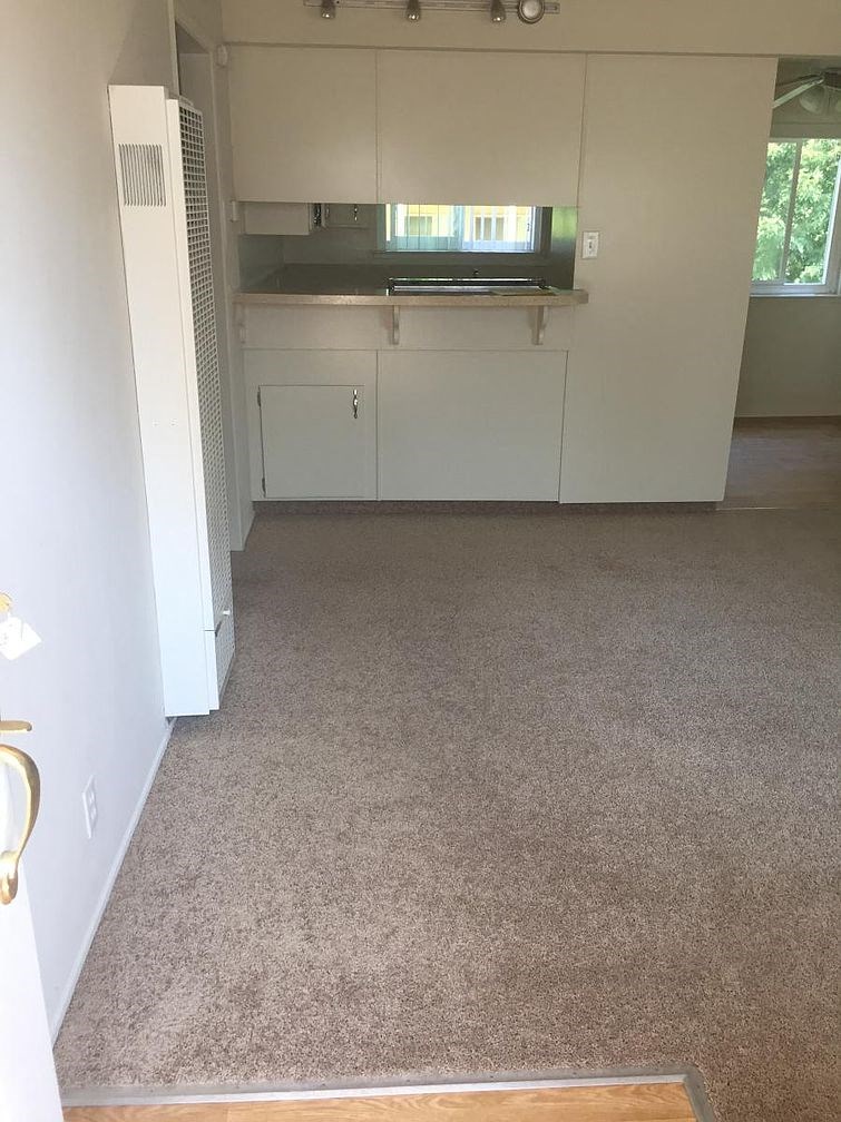 A kitchen with white cabinets and a white refrigerator.