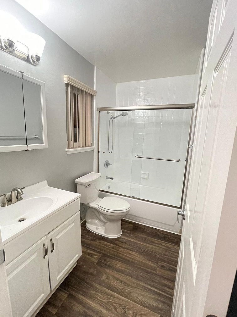 A white toilet sits in a bathroom next to a walk-in shower.