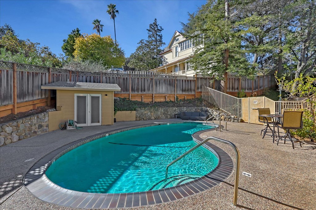 a pool with a house and trees in the background