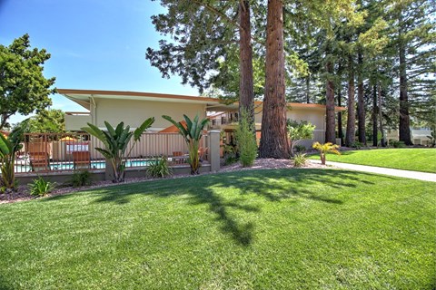 A house with a white roof and a green lawn in front.