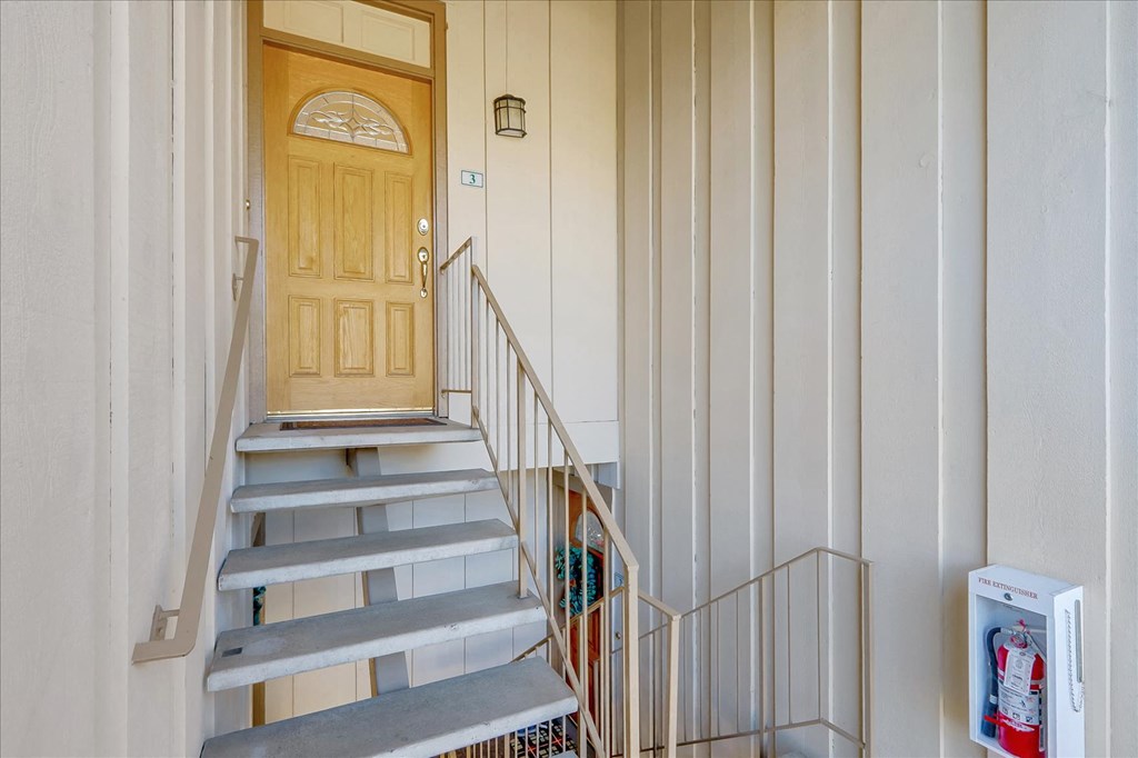 the front stairs of a house with a wooden door