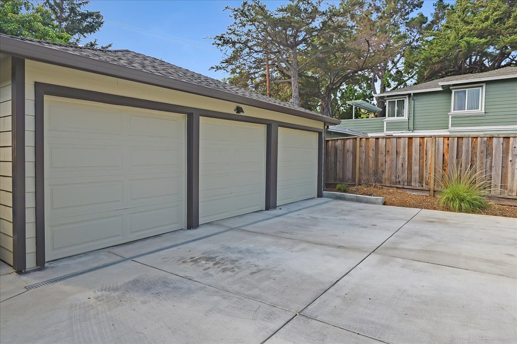 a garage with a concrete driveway and a row of garages