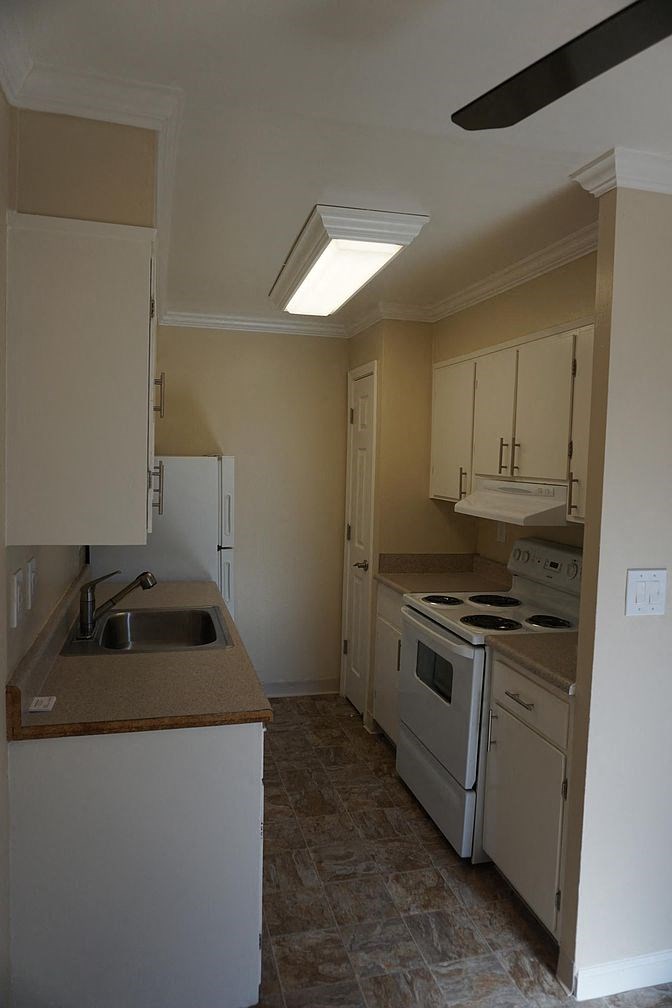 an empty kitchen with a stove and a sink