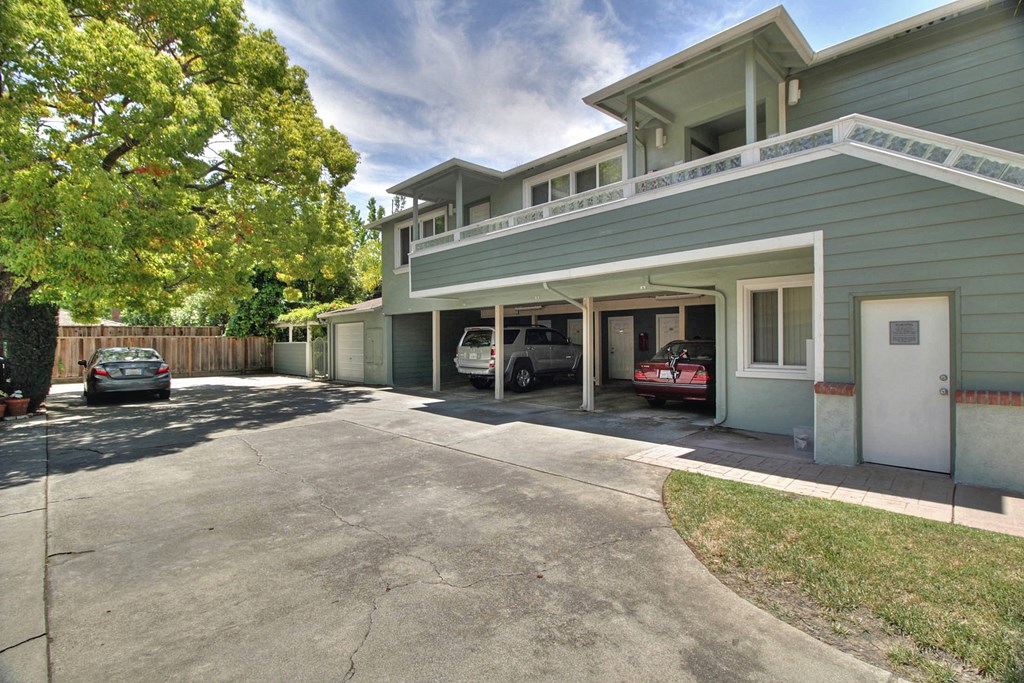 a garage with two cars parked in front of a house