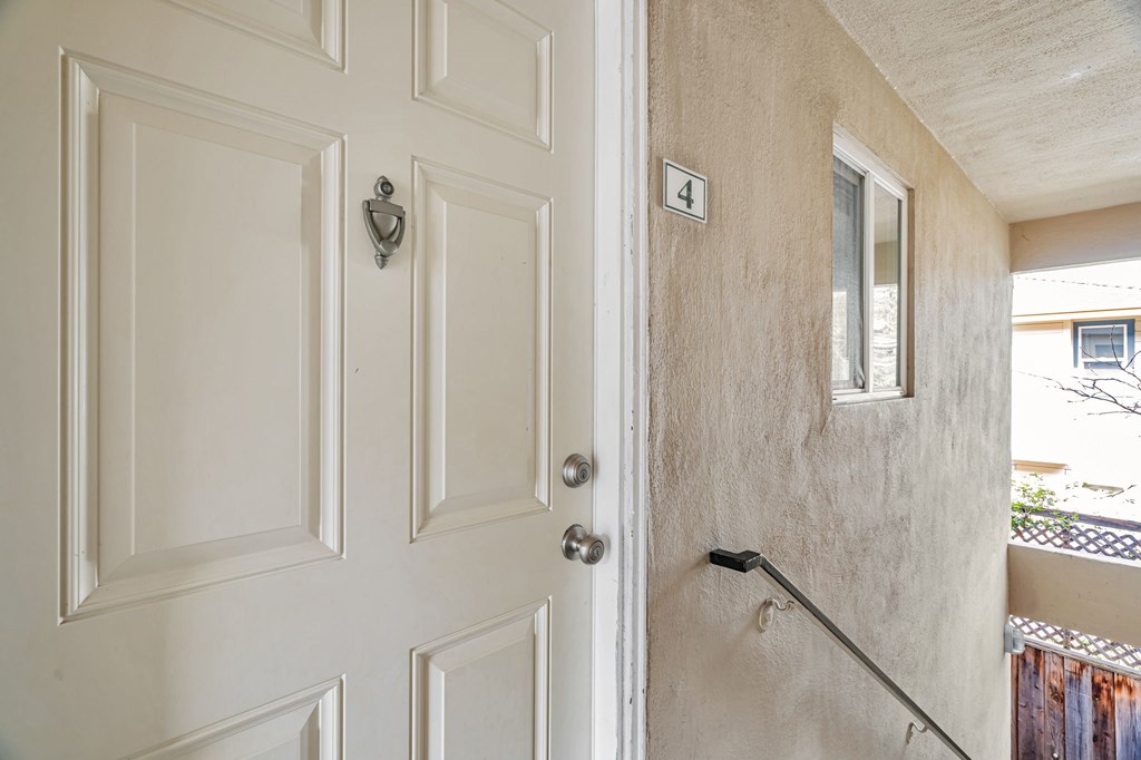A white door with a silver handle and a number 4 on the wall.