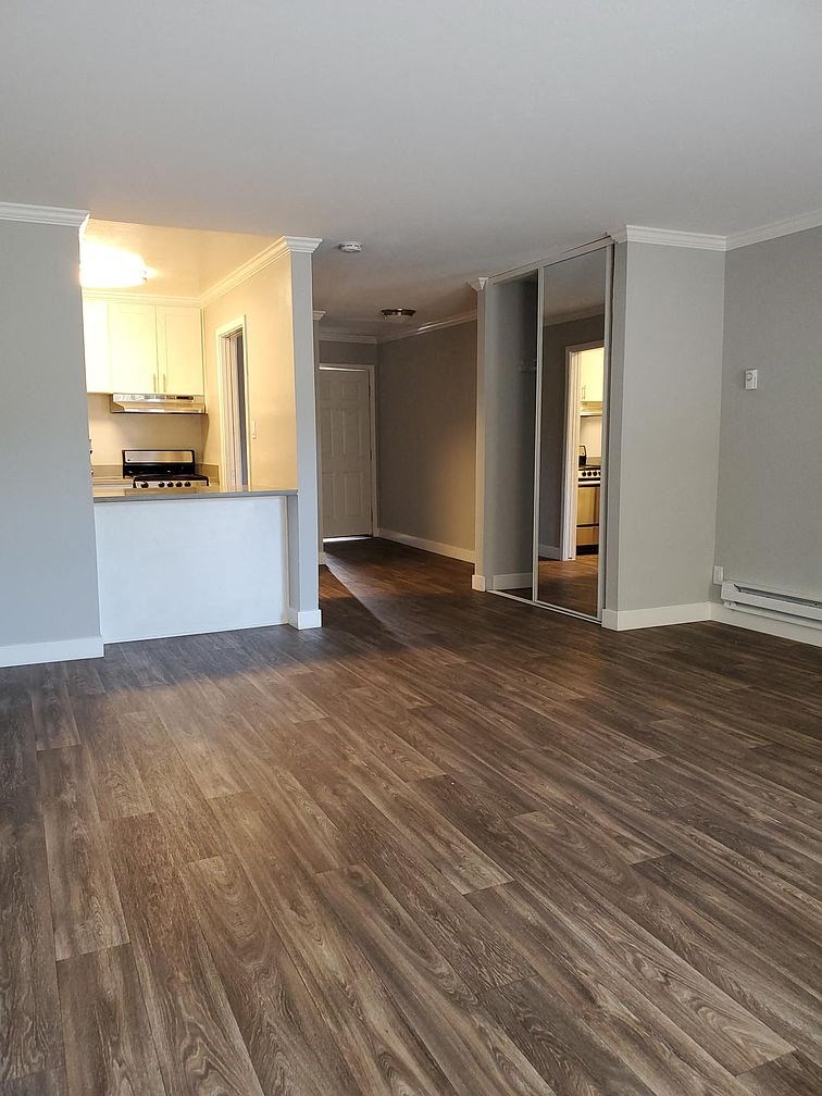 A room with a kitchen and a hallway.