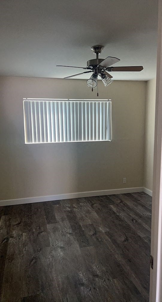 a empty room with a ceiling fan and a window