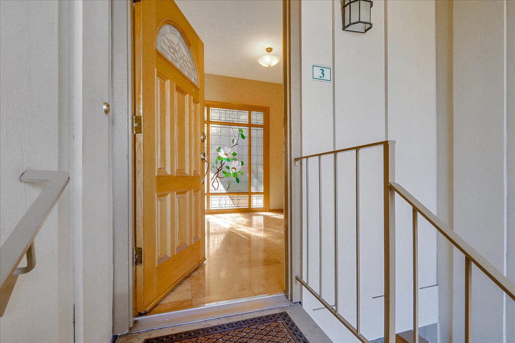 a view of a hallway with an open door and a staircase