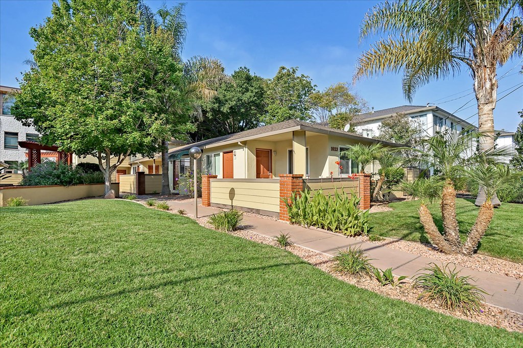 a small house with a yard and a sidewalk