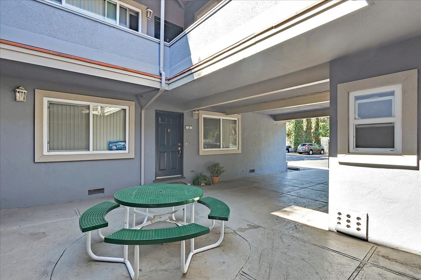 a patio with a table and chairs outside of a building
