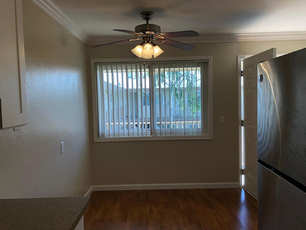 a living room with a large window and a ceiling fan