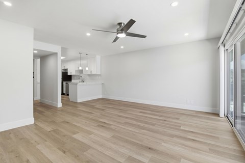 A spacious room with a ceiling fan and lighting fixtures.