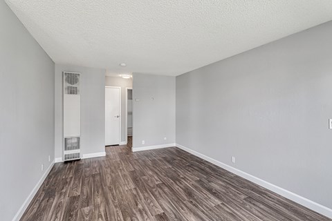 A room with wooden flooring and white walls.