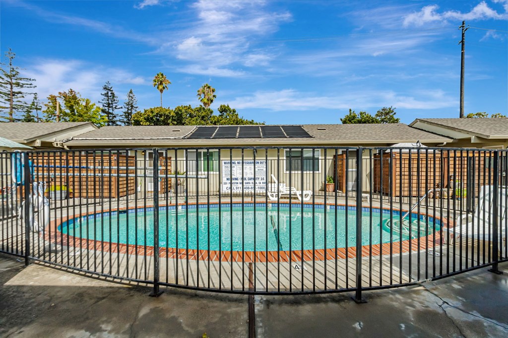 A pool surrounded by a black fence.