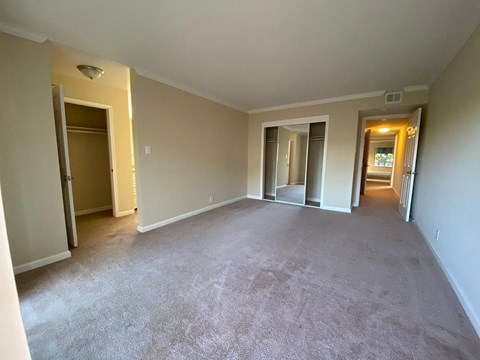 A spacious room with carpeted floor and white walls.