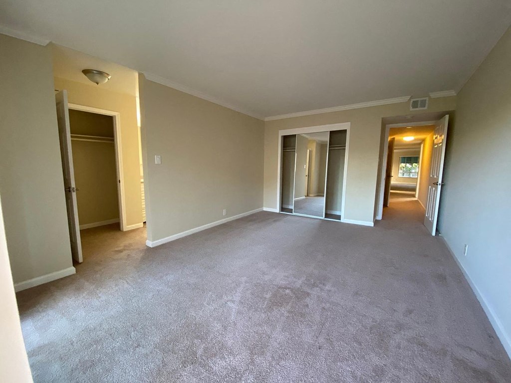 A spacious room with carpeted floor and white walls.