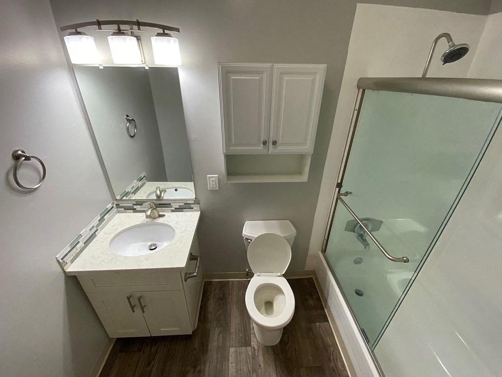 A bathroom with a toilet, sink, and shower.