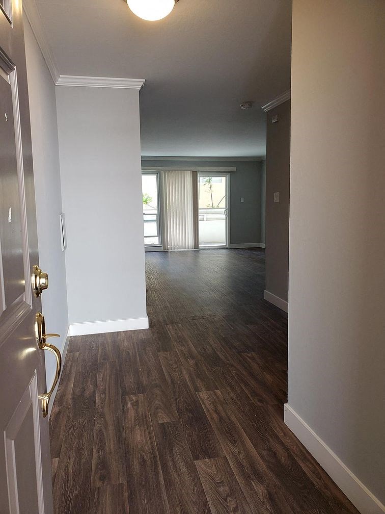 A hallway with wood floors and white walls.