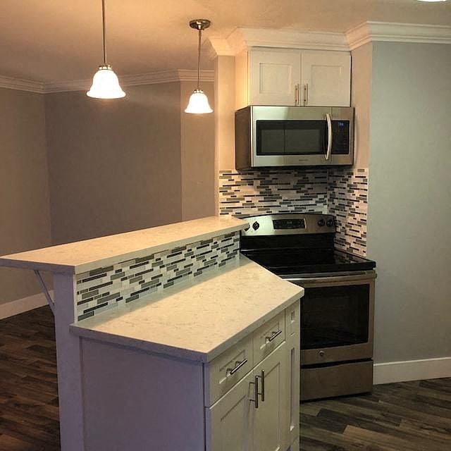 A kitchen with a stove top oven and a microwave above it.