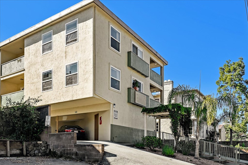 an apartment building with a driveway and a car parked in front