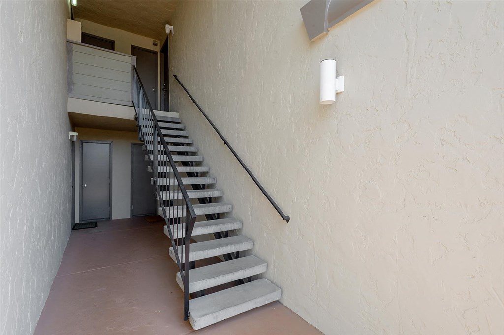 a set of stairs leading up to a hallway with a door
