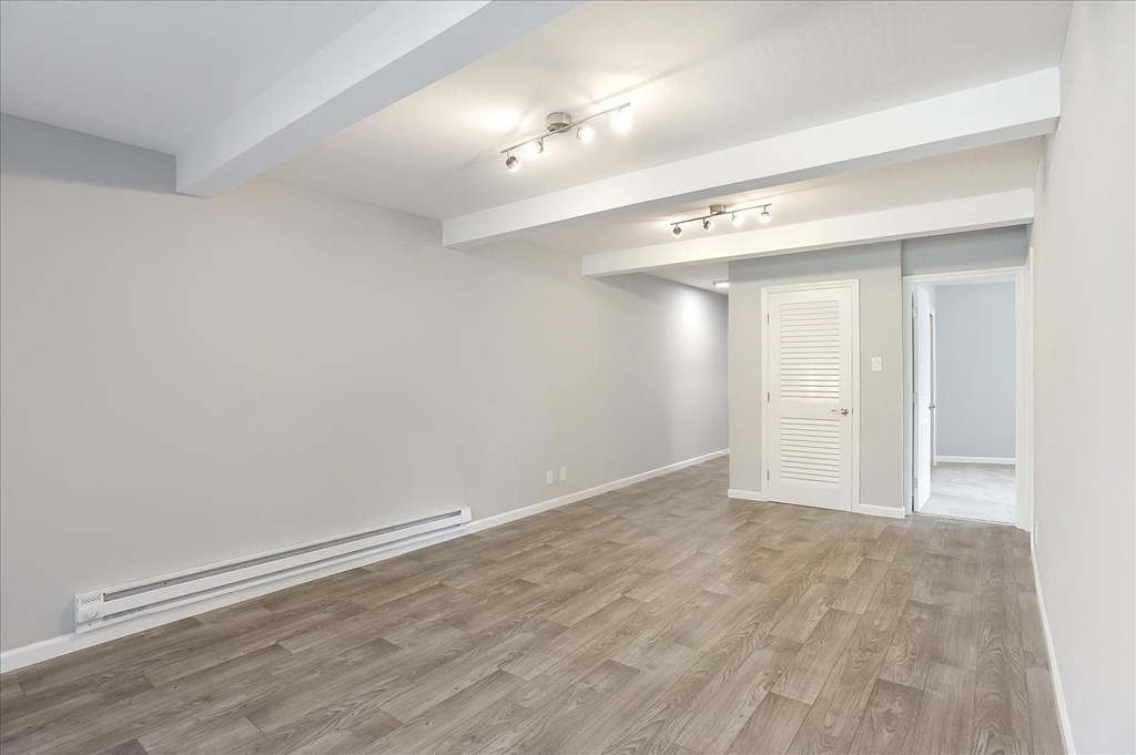 A room with wooden flooring and white walls.