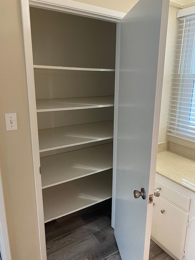 Empty white shelves in a pantry.
