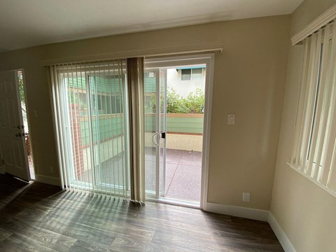 a living room with a sliding glass door to a balcony