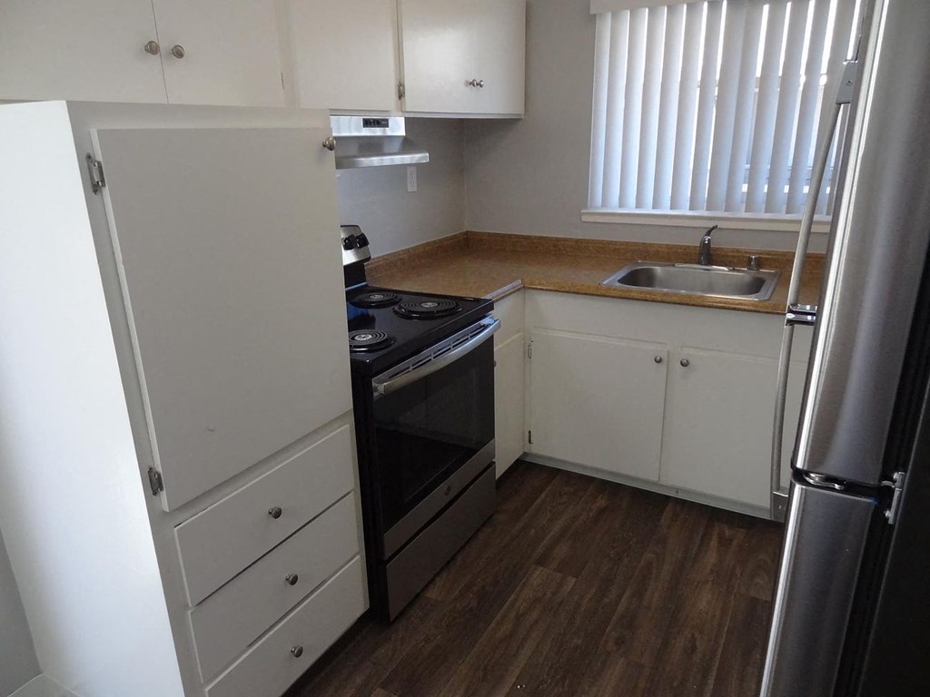 A kitchen with a black stove top oven and white cabinets.