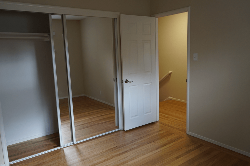 a room with a door open to a bathroom and a closet