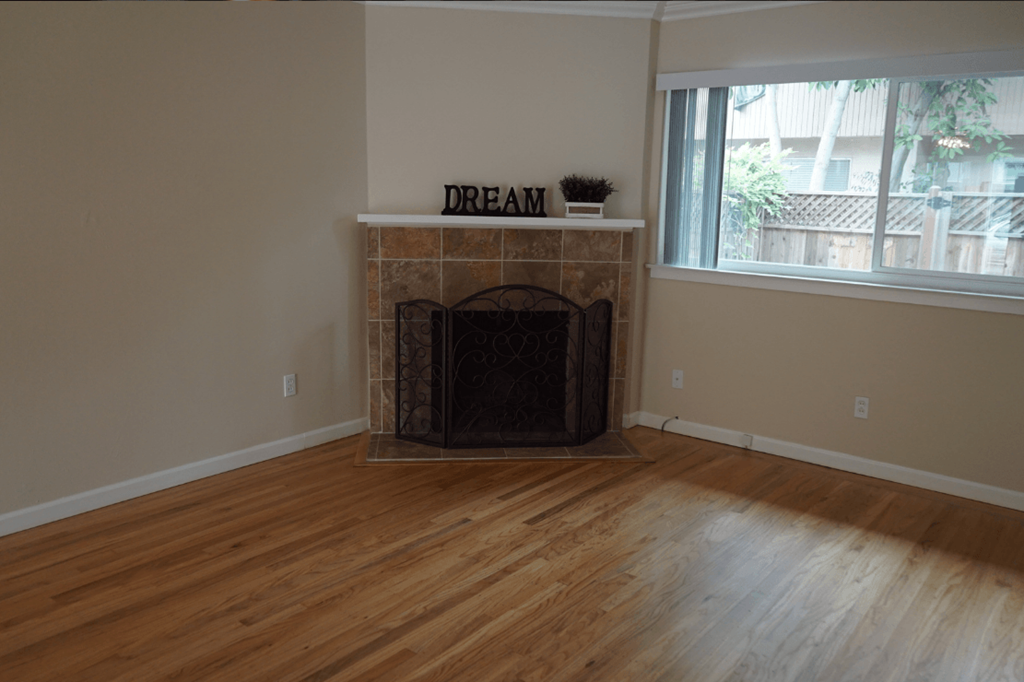 a living room with a fireplace and a wooden floor