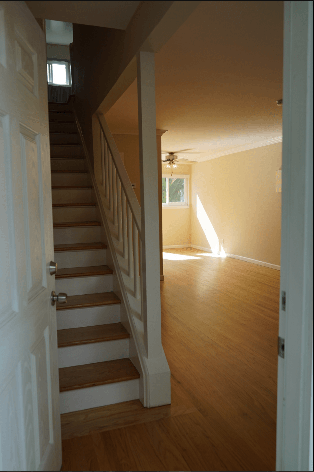 a view of a staircase in a home with wood flooring and a white door