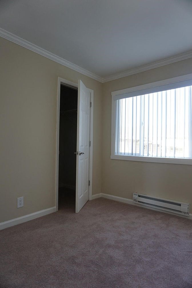 an empty living room with a window and a door
